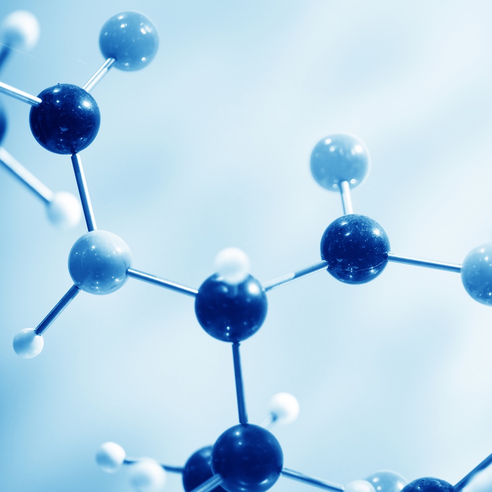 A close-up view of a molecular model, showcasing its intricate structure. The model is composed of variously sized spheres connected by rods, with the spheres featuring a range of blue hues and the rods appearing silver.